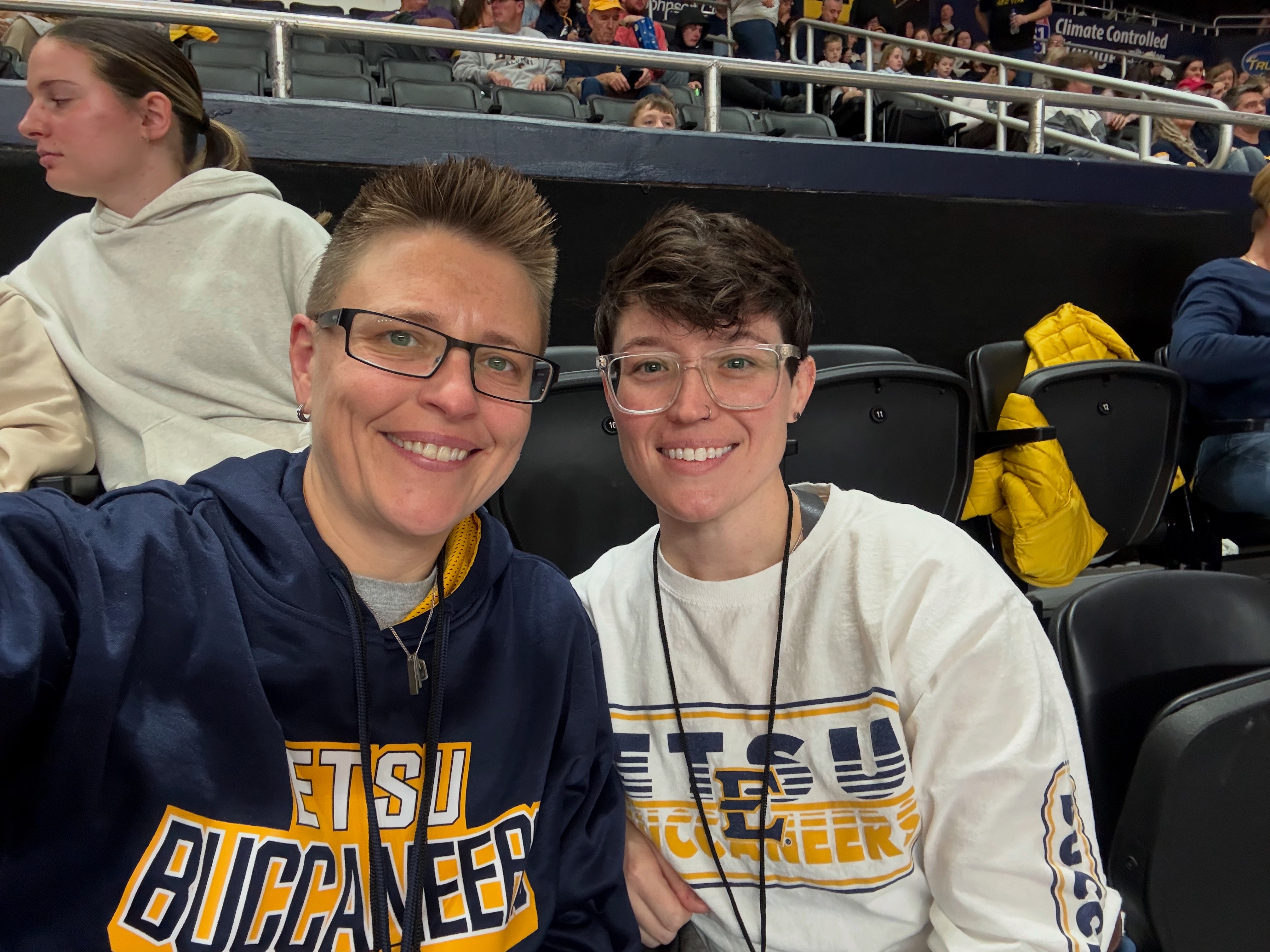 Kate with her wife cheering on the ETSU men's basketball team.