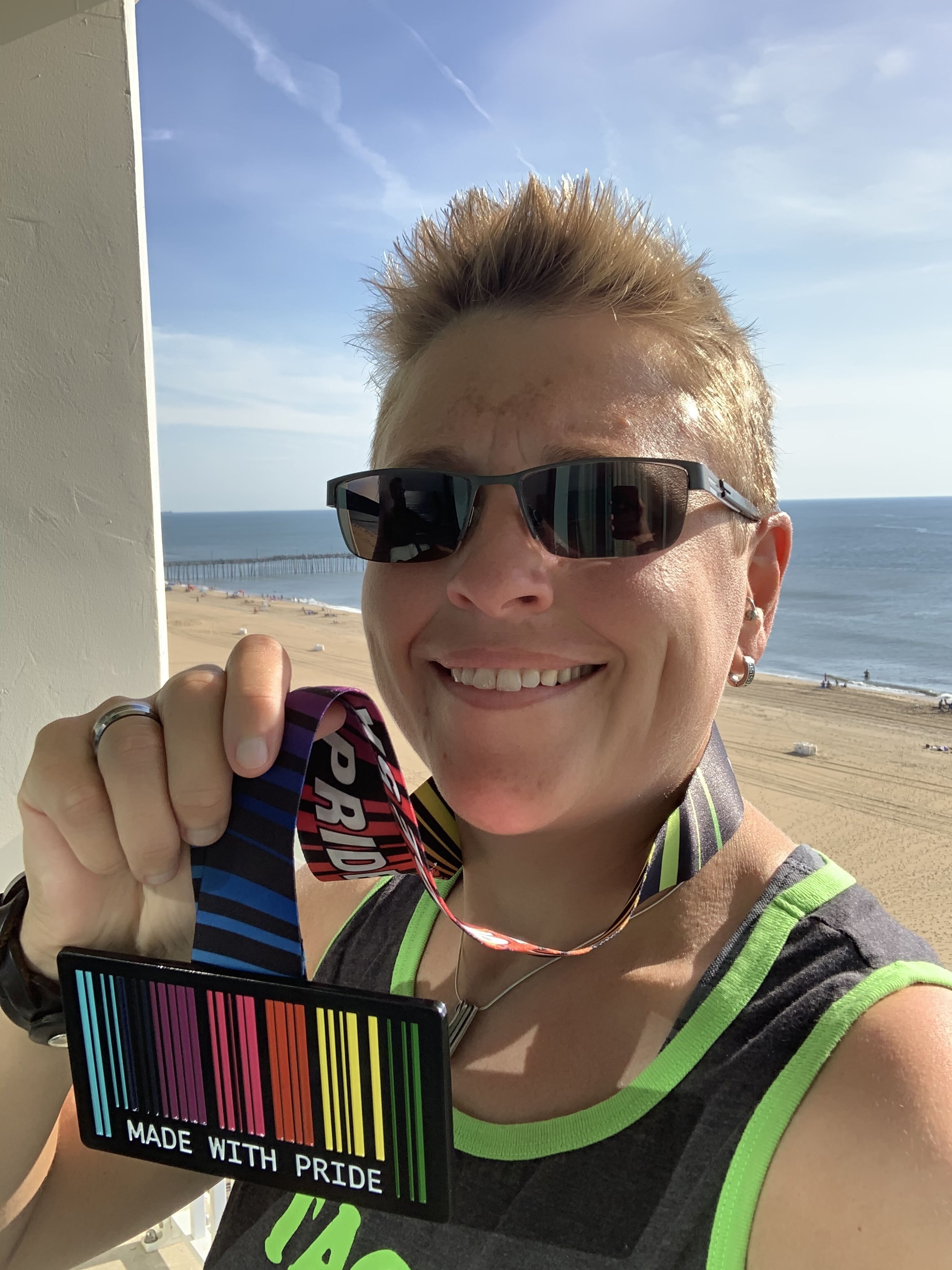 Kate holding up a medal after completing a 5K at Myrtle Beach, SC.