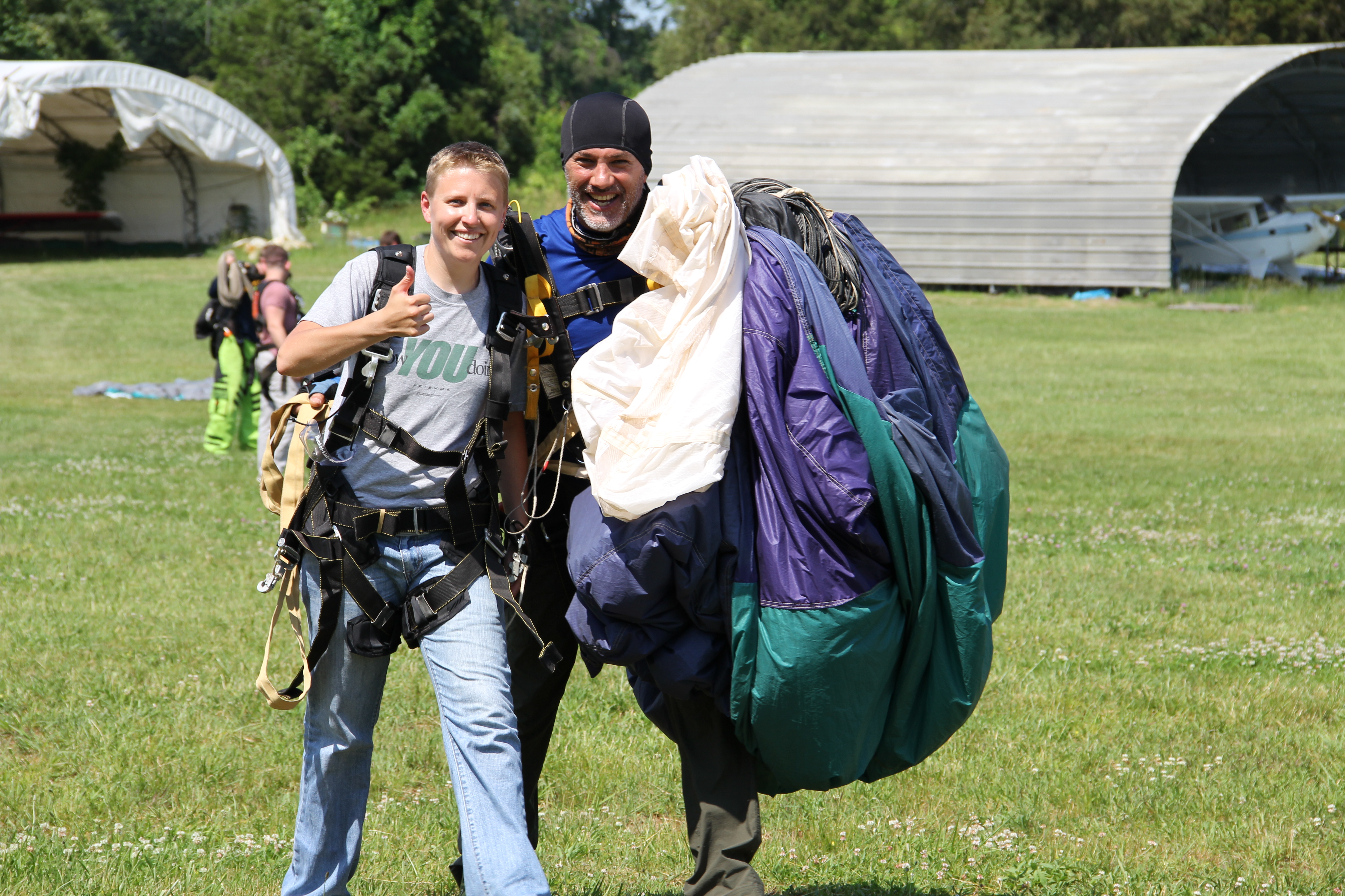 Kate on the ground with a parachute after skydiving.