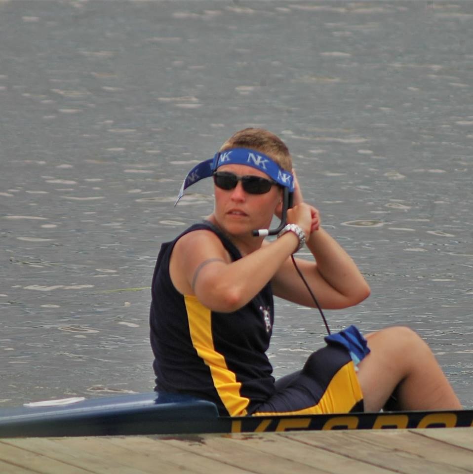 Kate in the coxswain seat of a rowing boat on the water.